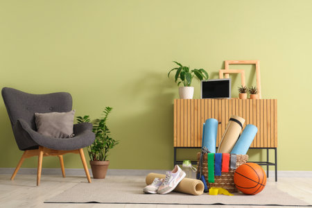 Interior of living room with sports equipment, commode and armchairの写真素材