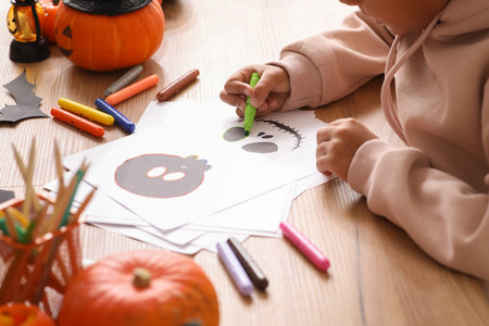 Teenage boy making Halloween card at table, closeup