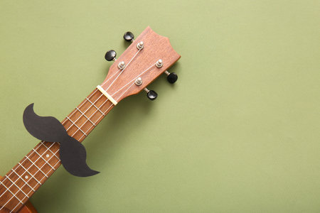 Guitar with paper mustache on color background, closeup. El Dia de Muertos