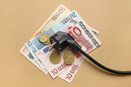Electric power plug and money on brown backgroundの写真素材