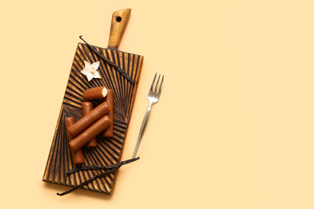 Wooden board with tasty chocolate glazed curd snacks with vanilla flavor on beige backgroundの写真素材