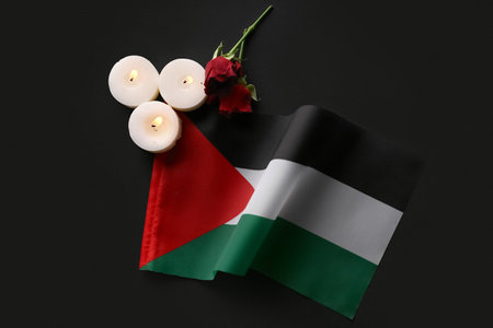 Flag of Palestine, rose flowers and burning candles on black backgroundの写真素材