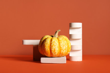 Decorative podiums with fresh pumpkin on colorful backgroundの写真素材