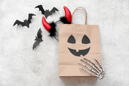 Composition with paper shopping bag and decorations for Halloween on light backgroundの写真素材