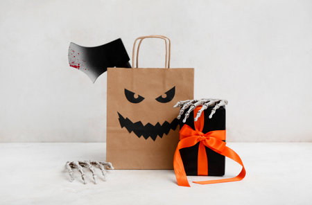 Paper shopping bag, gift box and decorations for Halloween on light backgroundの写真素材
