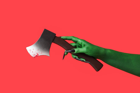 Green hand of witch with ax on red background. Halloween celebration