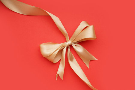 Beautiful bow made of satin ribbon on red backgroundの写真素材