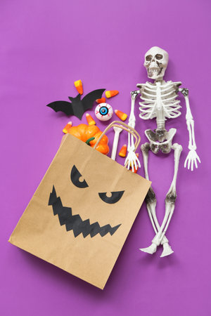 Composition with paper shopping bag and decorations for Halloween on color backgroundの写真素材