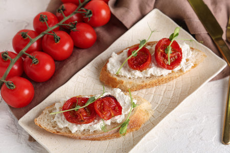 Plate of tasty tomato bruschetta with ricotta on white backgroundの写真素材