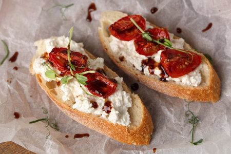 Baking paper of tasty tomato bruschetta with ricotta on table, closeupの写真素材