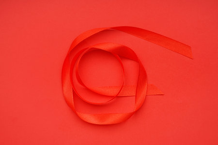 Red satin ribbon on color background