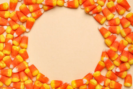 Frame made of tasty Halloween candy corns on color backgroundの写真素材
