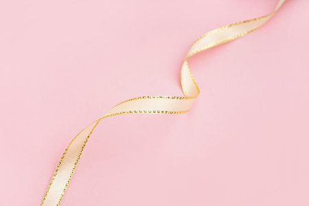 Beautiful satin ribbon on pink background