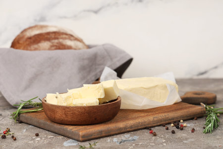 Wooden board with fresh butter, spices and bread on grunge table
