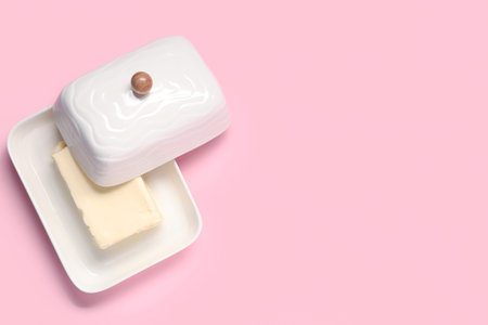 Ceramic dish with fresh butter on pink backgroundの写真素材
