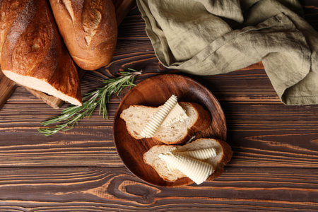 Sandwiches with fresh butter, rosemary and napkin on wooden background