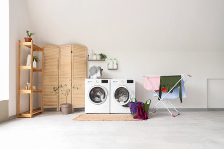 Interior of bathroom with washing machines, dryer and laundry basketの写真素材