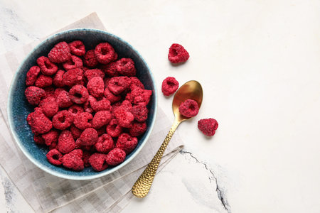 Bowl of dehydrated raspberries on white background