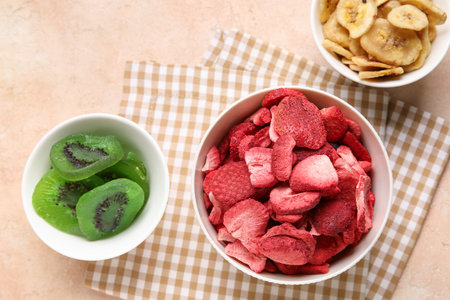 Bowls of different dehydrated fruits and berries on beige backgroundの写真素材