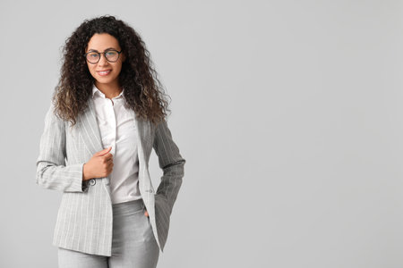Young African-American businesswoman on gray backgroundの写真素材