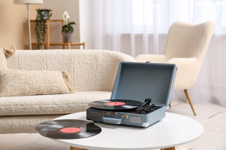 Record player with disks on coffee table in roomの写真素材