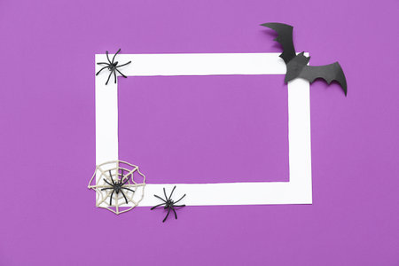 Blank frame and Halloween decorations on purple background, top viewの写真素材