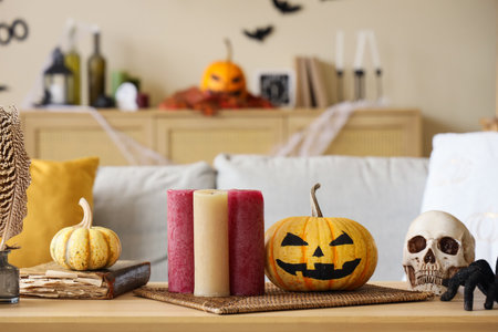 Halloween pumpkins with candles and skull on table in living room, closeupの写真素材