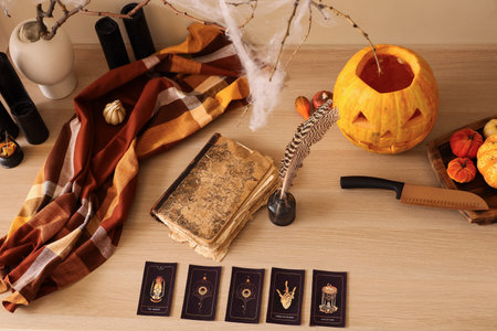 Halloween pumpkins with magic attributes on table in room, top view