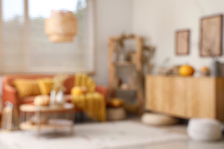 Orange sofa, pumpkins, chest of drawers and coffee table in autumn interior of living roomの写真素材
