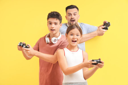 Father with his children playing video game on yellow background