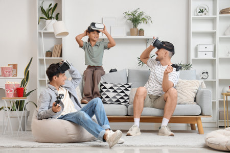 Father and his children with VR glasses playing video game at homeの写真素材