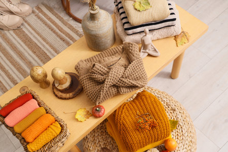 Different stylish clothes with autumn decorations on table in living room, top viewの写真素材