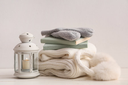 Beautiful composition with books, Christmas lantern and warm clothes on white backgroundの写真素材