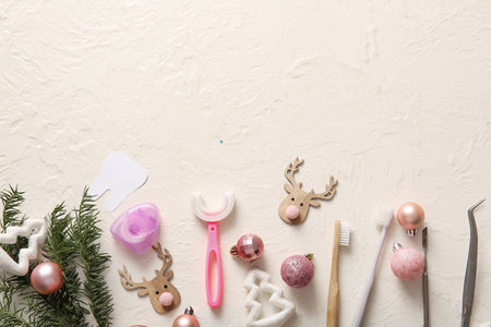 Composition with beautiful Christmas decorations and dentist's tools on light backgroundの写真素材