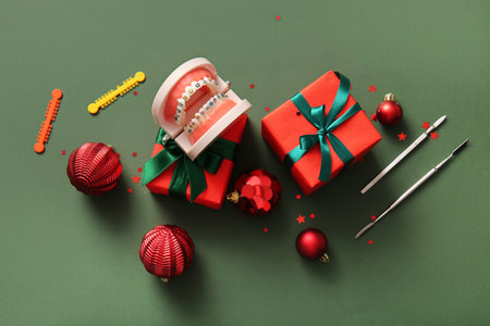 Composition with dentist's tools, Christmas gifts and decorations on green backgroundの写真素材