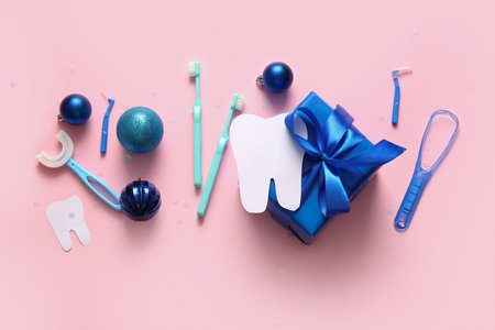 Composition with Christmas gift, dentist's tools and decorations on pink backgroundの写真素材