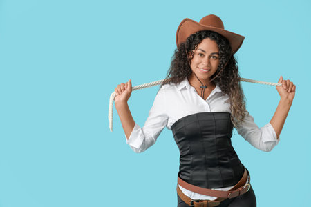 African-American cowgirl with rope on blue backgroundの写真素材