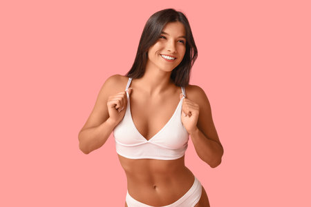 Beautiful young happy body positive woman in underwear on pink backgroundの写真素材