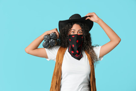 African-American cowgirl with dynamite on blue backgroundの写真素材