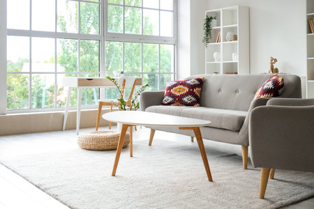 Interior of living room with gray sofa, armchair and tables