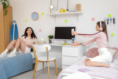 Female students resting on beds in dorm room