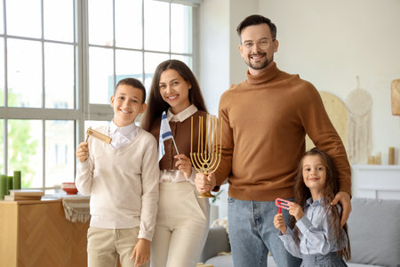Happy Jewish family with rattles, menorah and flag of Israel at homeの写真素材
