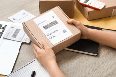 Female postal worker with parcel on table, closeup