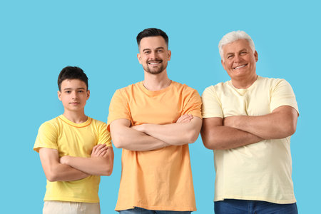 Teenage boy with his dad and grandfather on blue backgroundの写真素材