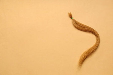 Red hair strand for donation on orange backgroundの写真素材