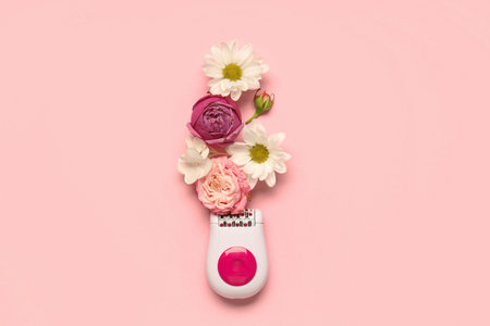 Modern epilator with flowers on pink background