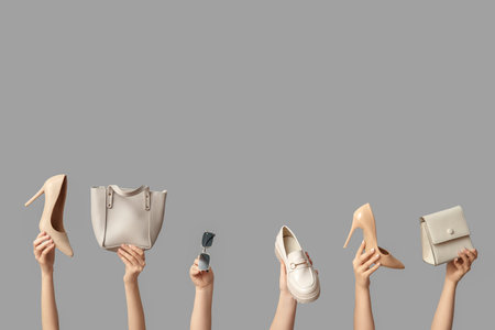 Female hands with bags, sunglasses and different shoes on gray backgroundの写真素材