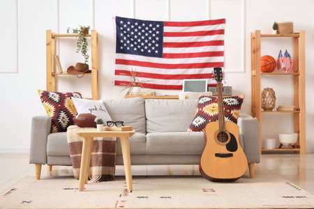 Interior of living room with gray sofa, rugby ball, guitar and USA flagの写真素材
