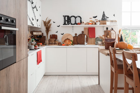 Interior of light kitchen decorated for Halloween with white counters and shelfの写真素材