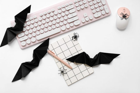 Composition with modern computer keyboard, mouse and Halloween decorations on white backgroundの写真素材